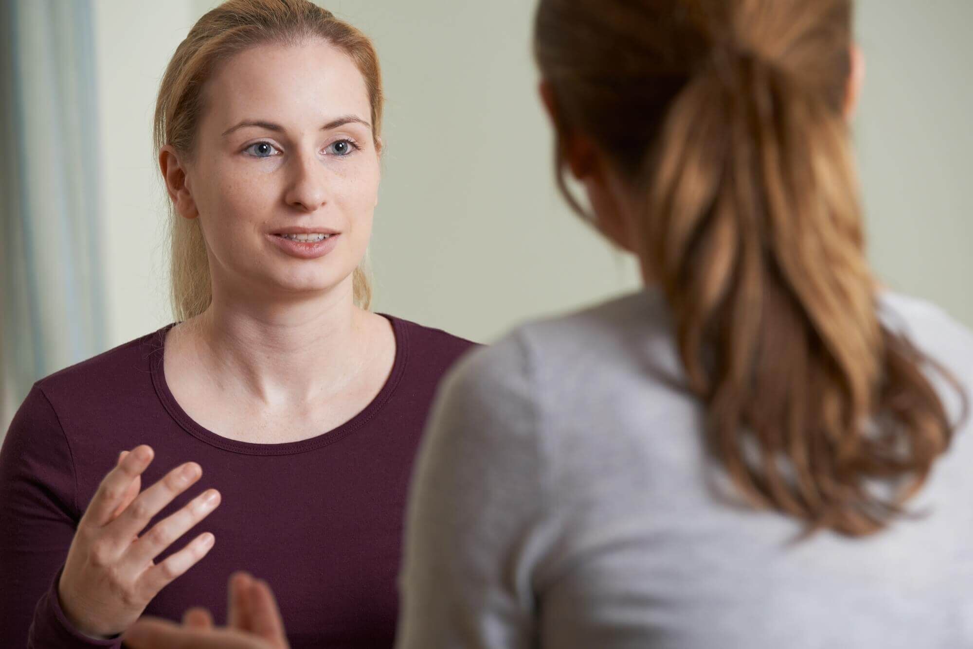 A woman speaking with a therapist who is listening attentively